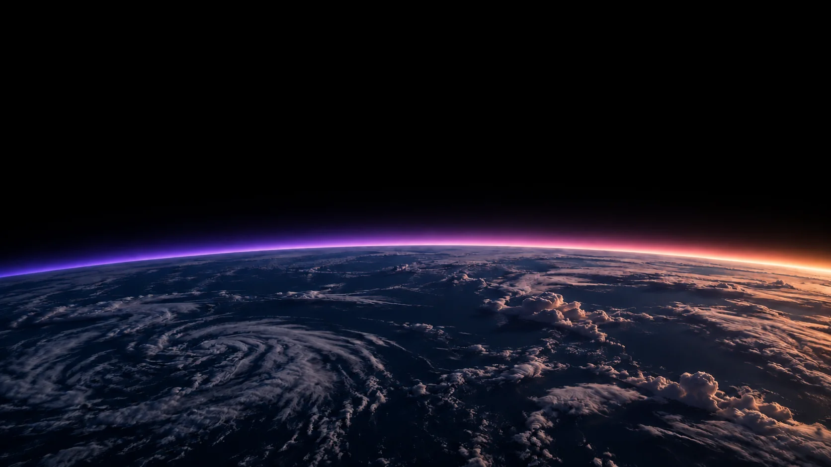 The Earth from orbit at dawn, light rising along the horizon