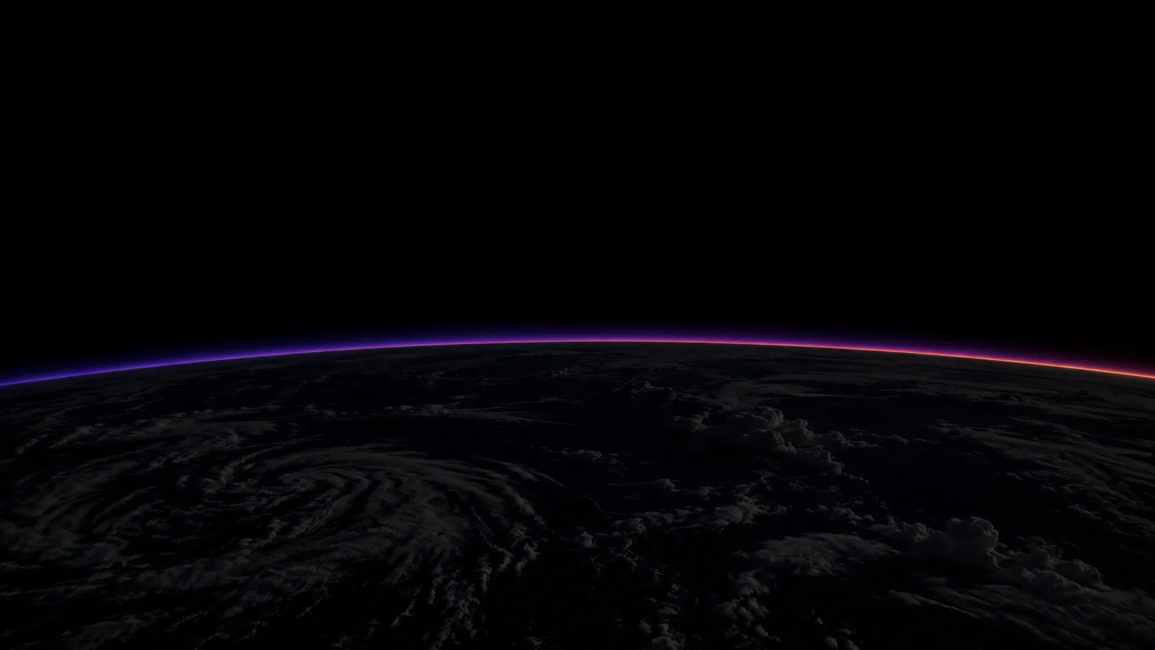 The Earth from orbit at night, with a thin glow along the horizon